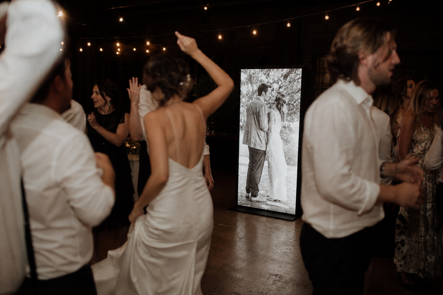 Dancing beside a glowing first-kiss photograph